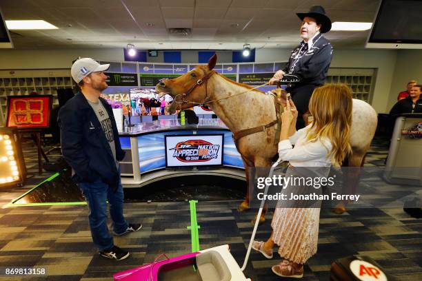 Dale Earnhardt Jr. , driver of the Nationwide/Justice League Chevrolet, and his wife, Amy Earnhardt , talk with Texas Motor Speedway president, Eddie...