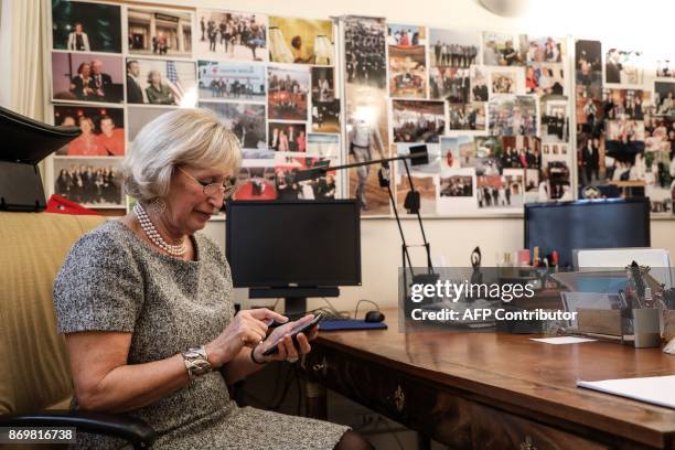 Evelyne Richard press office chief of the Elysee Palace for 48 years, looks at her mobile phone as she poses in her office at the Elysee Palace, in...