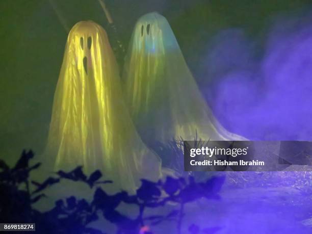 halloween illuminated ghost figures and artificial smoke used for halloween decoration. - dry ice halloween stock pictures, royalty-free photos & images