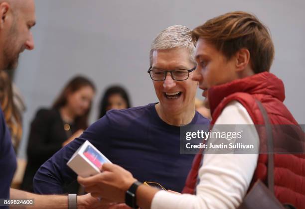 Apple CEO Tim Cook talks with a customer who just purchased the new iPhone X at an Apple Store on November 3, 2017 in Palo Alto, California. The...