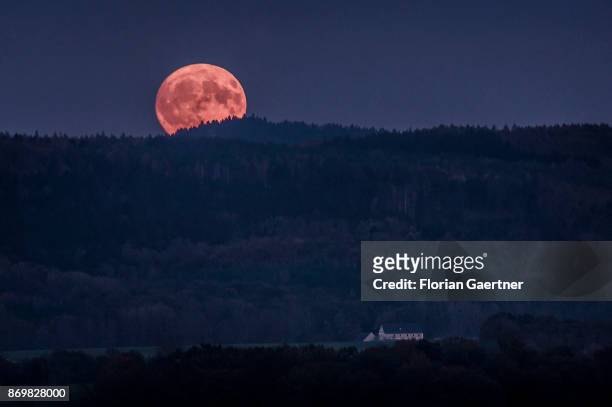 The full moon rises over the mountain 'Koenigshainer Berge' near the german-polish border in Saxony on November 03, 2017 in Koenigshain, Germany.