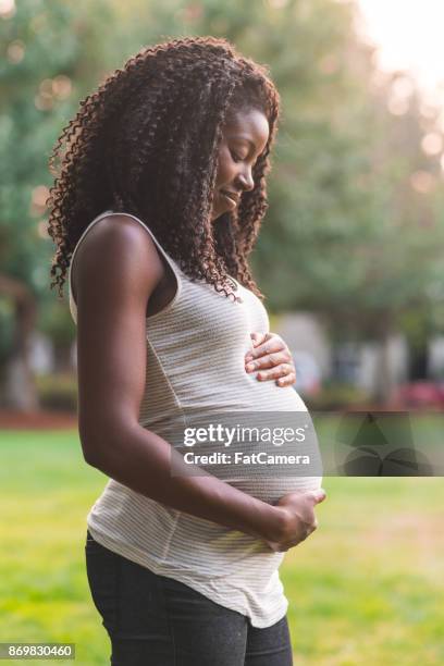 pregnant woman enjoys a few minutes of solitude in the park - girly pregnant stock pictures, royalty-free photos & images