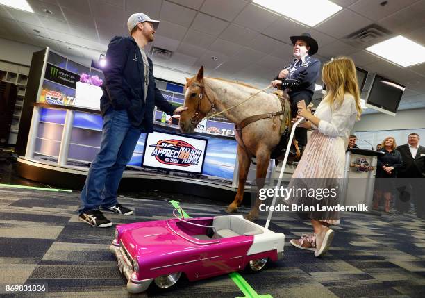 Dale Earnhardt Jr. , driver of the Nationwide/Justice League Chevrolet, and his wife, Amy Earnhardt , talk with Texas Motor Speedway president, Eddie...