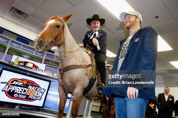 Dale Earnhardt Jr. , driver of the Nationwide/Justice League Chevrolet, speaks with Texas Motor Speedway president, Eddie Gossage, during a press...