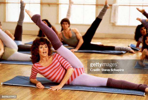 Along with unidentified others, American actress Jane Fonda exercises during a photo shoot for 'Jane Fonda's Workout Book,' Los Angeles, California,...