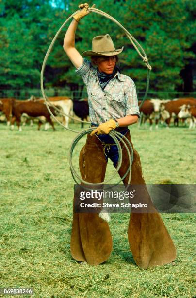View of American actress Jane Fonda , in costume, as she wields a lasso on the set of the film 'Comes a Horseman' , Arizona, 1977.
