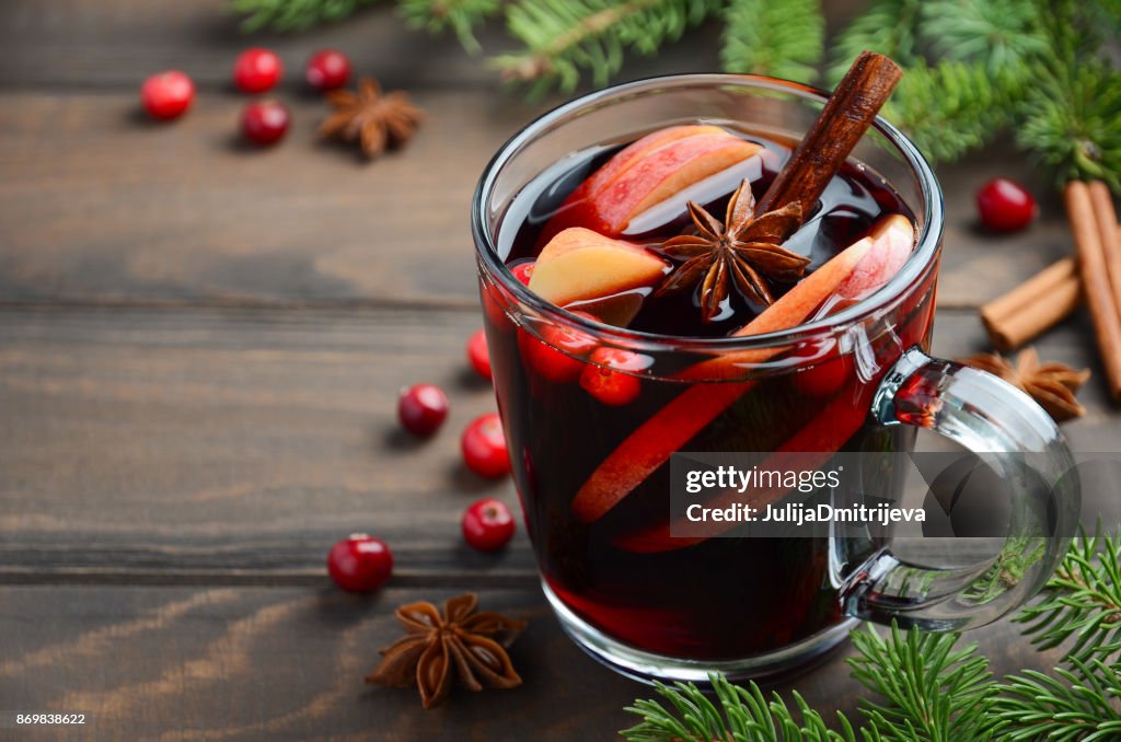 Christmas Mulled Wine with Apple and Cranberries. Holiday Concept Decorated with Fir Branches, Cranberries and Spices.