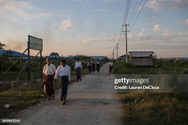 Rakhine Buddhists walk past the Narzi Quarter on November 3, 2017 in Sittwe, Myanmar. The Narzi Quarter was once home to 100,000 Rohingya Muslims...