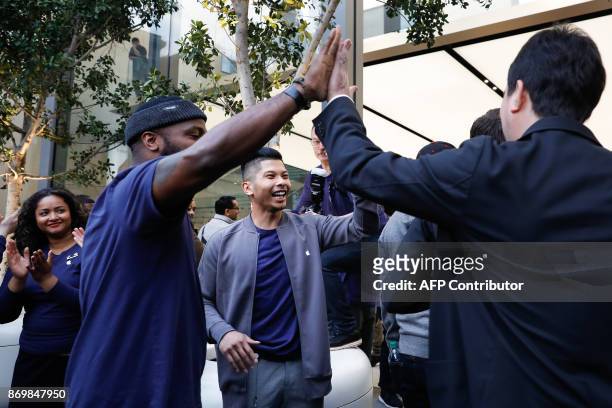 Apple employees greet customers as they enter the store to purchase the iPhone X at the Apple Store Union Square on November 3 in San Francisco,...