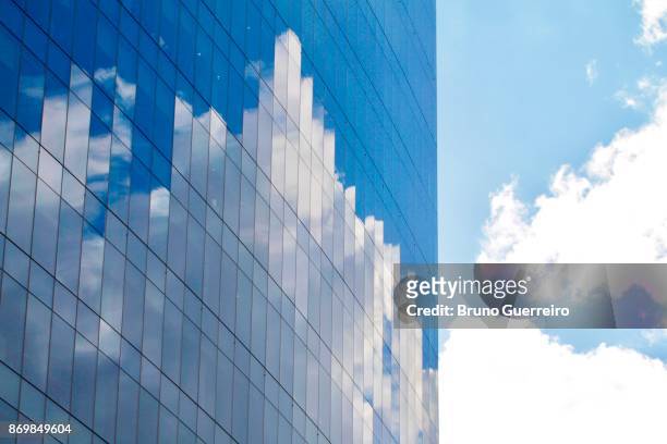reflection of clouds and sky on modern glass building - building office foto e immagini stock