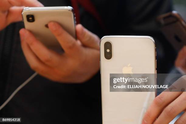 Customers handle the new iPhone X at the Apple Store Union Square on November 3 in San Francisco, California. - Apple's iPhone X hit stores around...