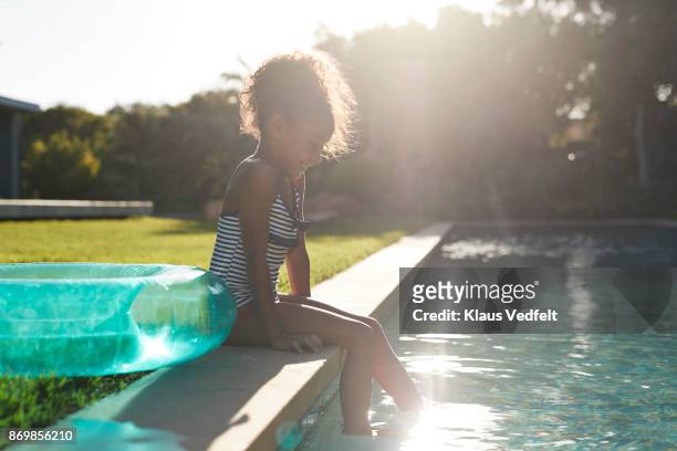 young girl dipping her feet in the water - testing the water 英語の慣用句 ストックフォトと画像
