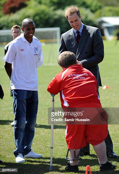 Prince William, President of The Football Association and footballer Ashley Young meet a member player on crutches as they visit Kingshurst Sporting...