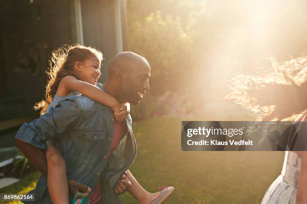 parents playing with their kids in the garden - piggy back and men only stockfoto's en -beelden