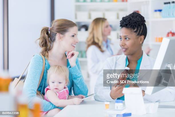 african american pharmacist consults with customer - pharmacist and patient stock pictures, royalty-free photos & images
