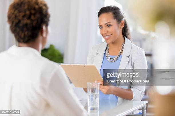 fröhliche weibliche psychische gesundheit professionelle hört patient - arzthelferin stock-fotos und bilder
