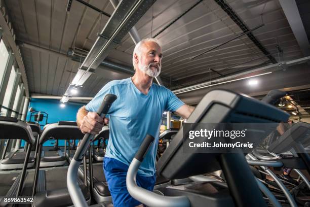 gesunde älterer mann halten fit im fitnessraum auf einem cross-trainer - cross trainer stock-fotos und bilder