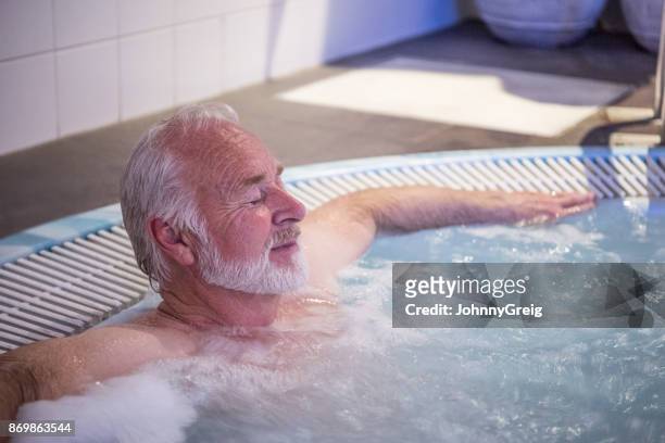 senior man relaxing in hot tub with his eyes closed - country club stock pictures, royalty-free photos & images