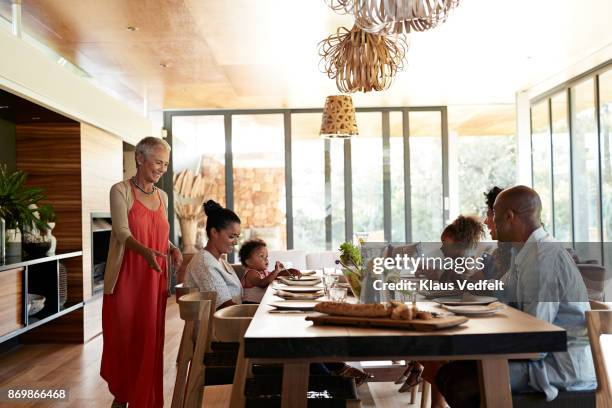 multigenerational family having weekend lunch - african at dining table stockfoto's en -beelden