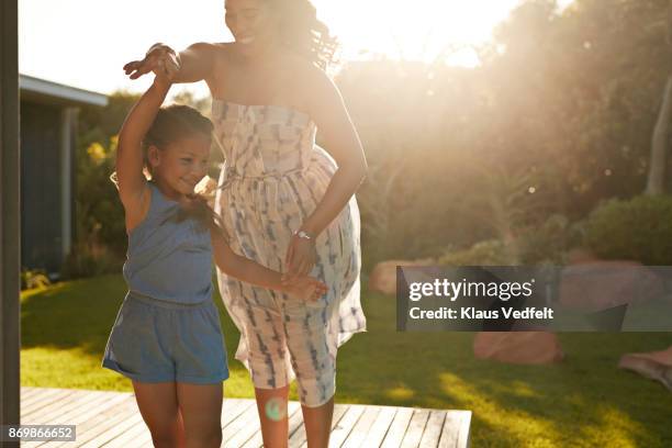 mother and daughter playing and laughing in their garden - children dancing outside stock pictures, royalty-free photos & images