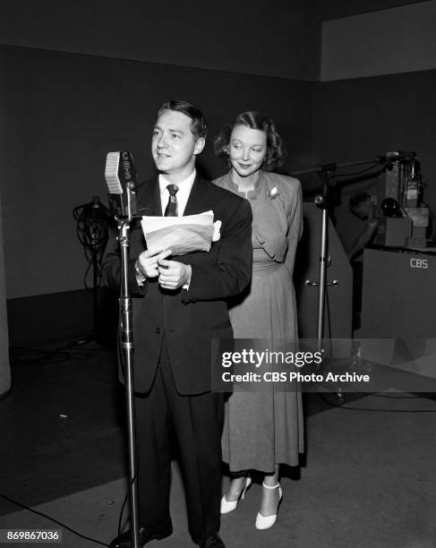 Johnny Jacobs announces while hostess Virginia Bruce looks on with obvious approval on the CBS Radio program "Make Believe Town." "Make Believe...