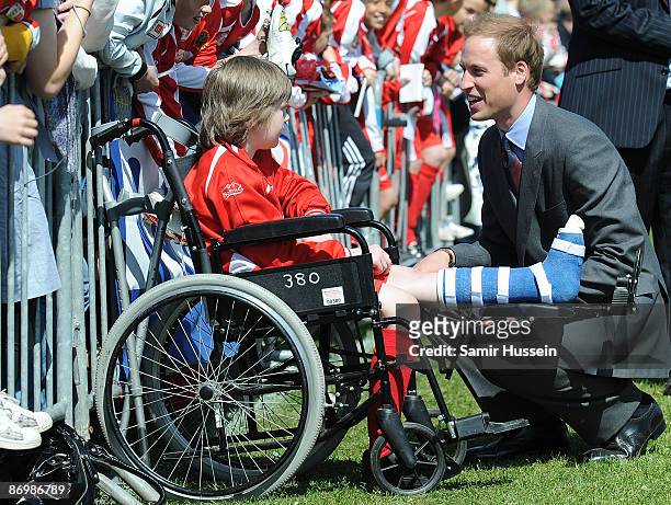 Prince William, President of The Football Association meets a boy with his leg in plaster as he visits Kingshurst Sporting FC on May 11, 2009 in...