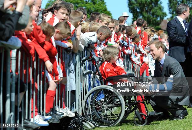 Prince William, President of The Football Association meets a boy with his leg in plaster as he visits Kingshurst Sporting FC on May 11, 2009 in...