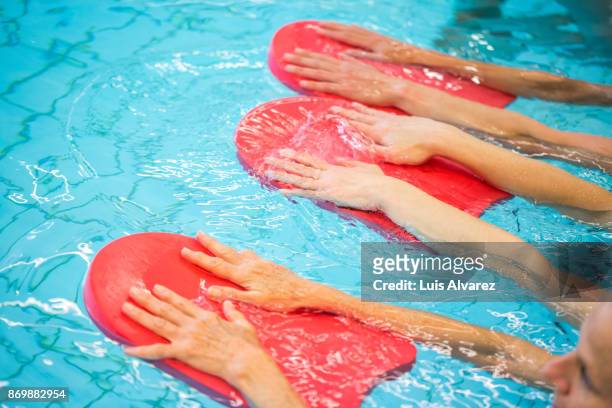 cropped hands of mature women exercising in swimming pool - see through swimsuit fotografías e imágenes de stock