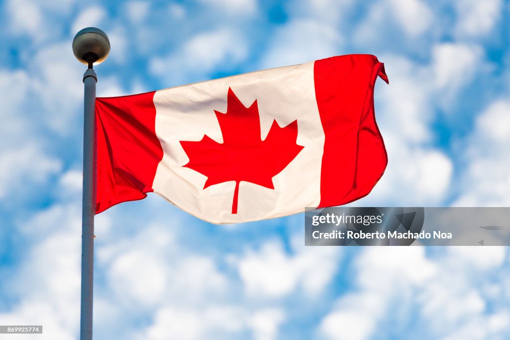 Toronto,Canada: Canadian National Flag Waving on a partially cloudy sky