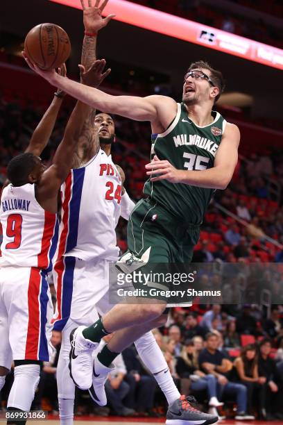 Mirza Teletovic of the Milwaukee Bucks shoots around Eric Moreland of the Detroit Pistons during the first half at Little Caesars Arena on November...