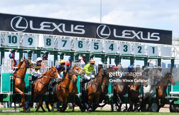 Stephen Baster riding Cismontane jumps out of barriers before winning Race 4, Lexus Stakes on Derby Day at Flemington Racecourse on November 4, 2017...