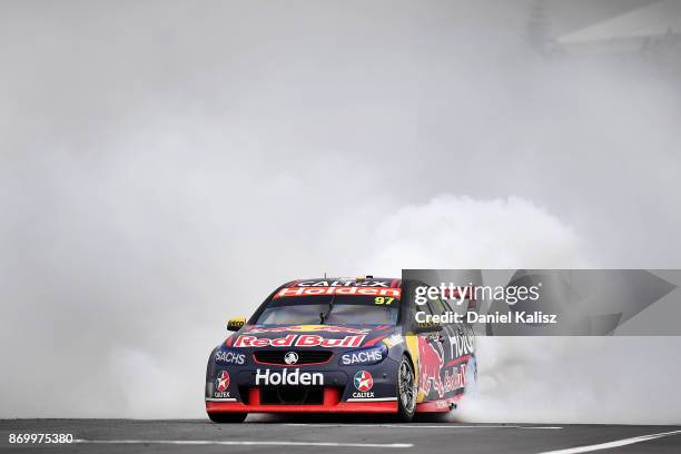 Shane Van Gisbergen drives the Red Bull Holden Racing Team Holden Commodore VF celebrates with a burnout after winning race 23 for the Auckland...