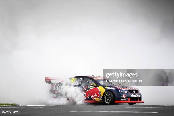 Shane Van Gisbergen drives the Red Bull Holden Racing Team Holden Commodore VF celebrates with a burnout after winning race 23 for the Auckland...