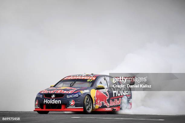 Shane Van Gisbergen drives the Red Bull Holden Racing Team Holden Commodore VF celebrates with a burnout after winning race 23 for the Auckland...