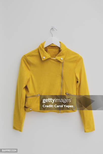 yellow jacket hung on rack in diy fashion studio workshop space - shirt no people stock-fotos und bilder