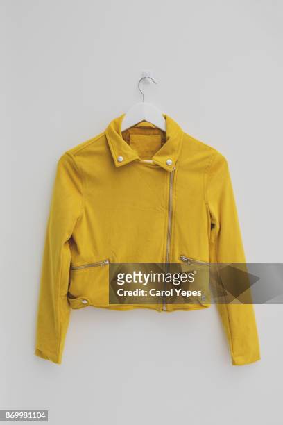 yellow jacket hung on rack in diy fashion studio workshop space - jacket stock pictures, royalty-free photos & images