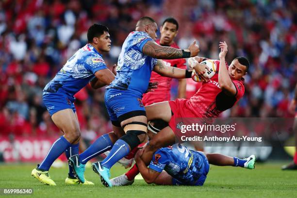 Sio Siua Taukeiaho of Tonga is tackled by Junior Paulo of Samoa during the 2017 Rugby League World Cup match between Samoa and Tonga at Waikato...