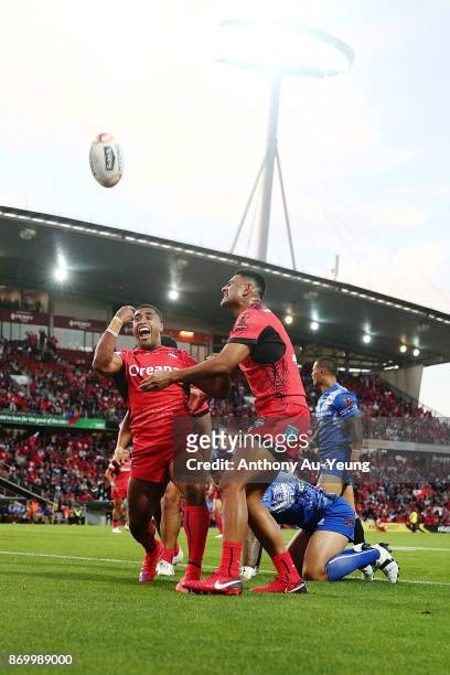 Michael Jennings of Tonga celebrates with teammates after scoring a try during the 2017 Rugby League World Cup match between Samoa and Tonga at...