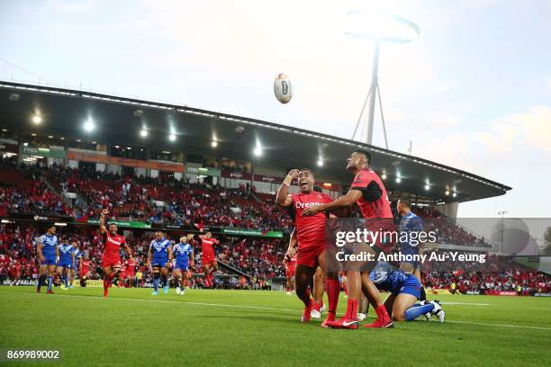 Michael Jennings of Tonga celebrates with teammates after scoring a try during the 2017 Rugby League World Cup match between Samoa and Tonga at...