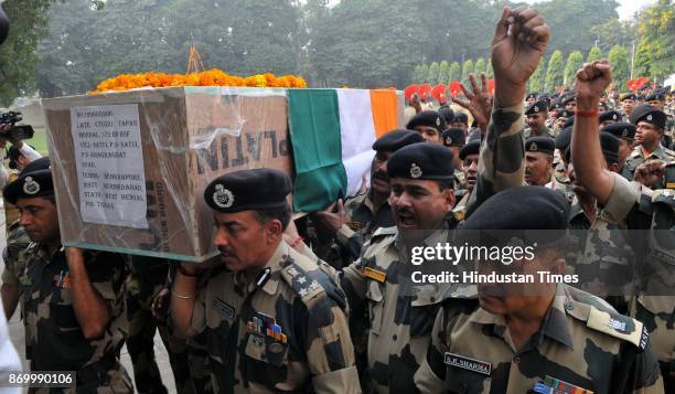 Border Security Force officers carry the coffin after paying homage to BSF soldier constable Tapan Mondal during a wreath-laying ceremony on November...