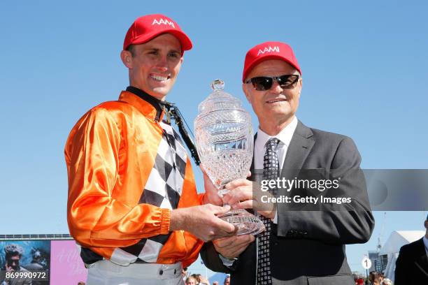 Jockey Tye Angland and trainer David Payne pose with the trophy after winning the AAMI Victoria Derby with their horse Ace High on Derby Day at...