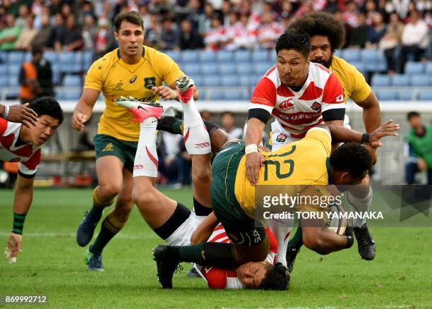 Samu Kerevi of Australia is tackled during the rugby union test match between Japan and Australia in Yokohama, suburb of Tokyo, on November 4, 2017.