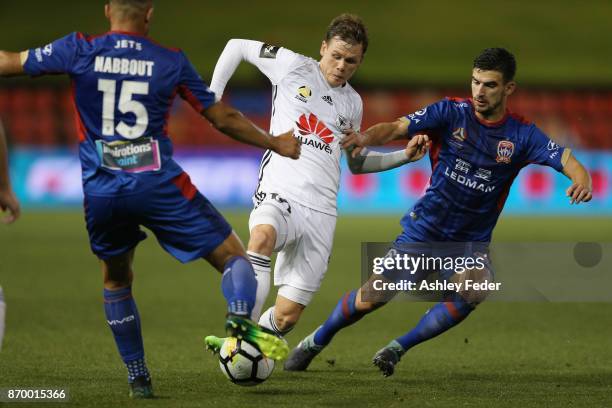 Michael McGlinchey of the Phoenix is tackled by the Jets defence during the round five A-League match between the Newcastle Jets and the Wellington...