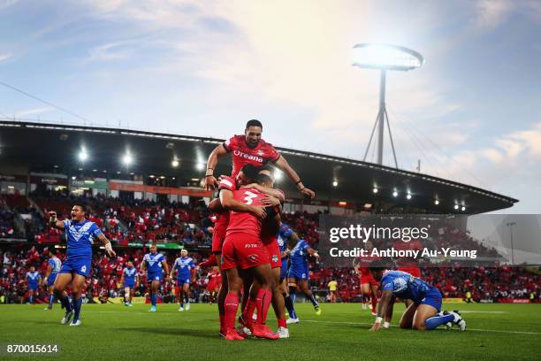 Michael Jennings of Tonga is mobbed by teammates after scoring a try during the 2017 Rugby League World Cup match between Samoa and Tonga at Waikato...