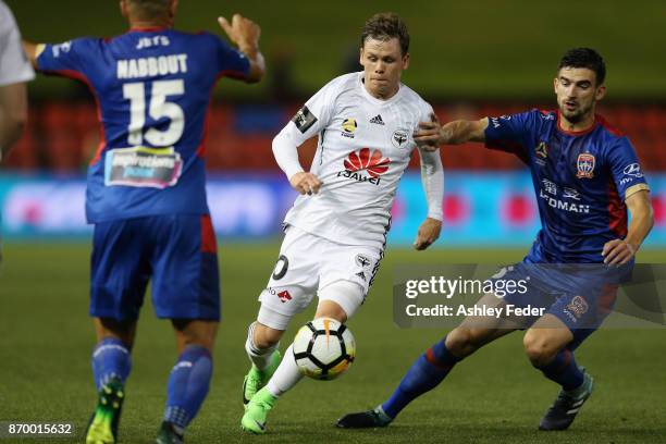 Michael McGlinchey of the Phoenix is tackled by the Jets defence during the round five A-League match between the Newcastle Jets and the Wellington...