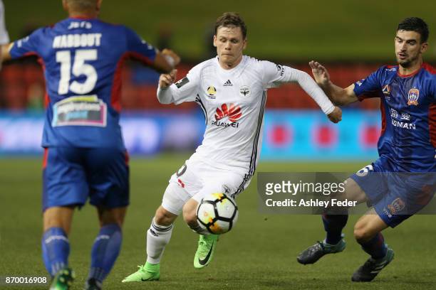 Michael McGlinchey of the Phoenix is tackled by the Jets defence during the round five A-League match between the Newcastle Jets and the Wellington...