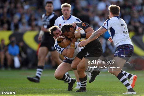 Martin Taupau of the Kiwis is tackled by Luke Douglas of Scotland during the 2017 Rugby League World Cup match between the New Zealand Kiwis and...