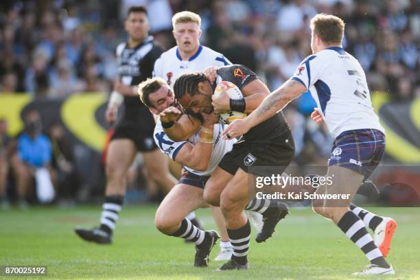 Martin Taupau of the Kiwis is tackled by Luke Douglas of Scotland during the 2017 Rugby League World Cup match between the New Zealand Kiwis and...