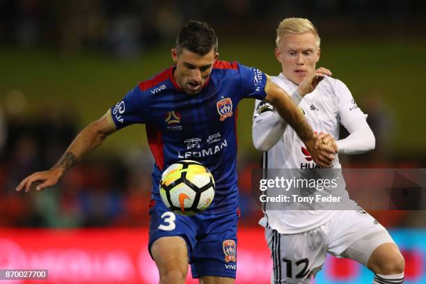 Jason Hoffman of the Jets contests the ball with Adam Parkhouse of the Phoenix during the round five A-League match between the Newcastle Jets and...