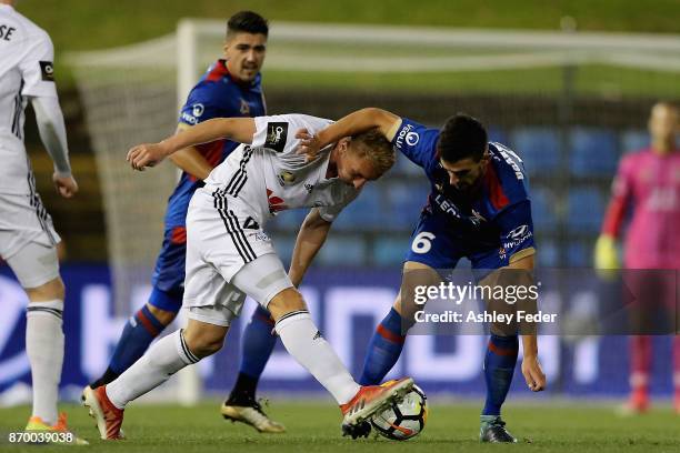 Steven Ugarkovic of the Jets is contested by the Phoenix defence during the round five A-League match between the Newcastle Jets and the Wellington...